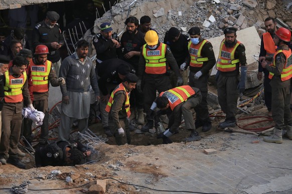 epa10439968 Rescue workers at the scene after a blast at a Mosque, in Peshawar, Pakistan, 30 January 2023. At least 28 worshippers were killed and dozens injured in a blast during prayers at a Mosque  ...