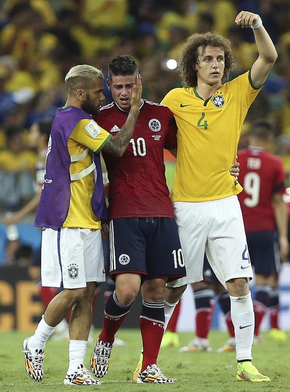 Les Brésiliens David Luiz (à droite) et Dani Alves tentent de consoler James Rodriguez après l'élimination de la Colombie au Mondial 2014.