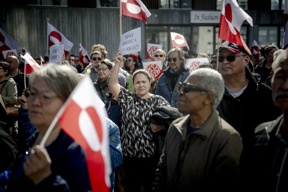 epa12982498 A demonstrator (C) holds a sign that reads 'Make America go away' as others wave flags during a protest outside the US consulate in Nuuk, Greenland, 21 May 2026. The new diplomat ...