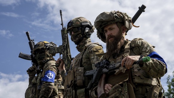 FILE - Fighters of Russian Volunteer Corps stand atop on an APC during press conference not far from the Ukraine&#039;s border with Russia in Sumy region, Ukraine, on May 24, 2023. Fighters from Ukrai ...