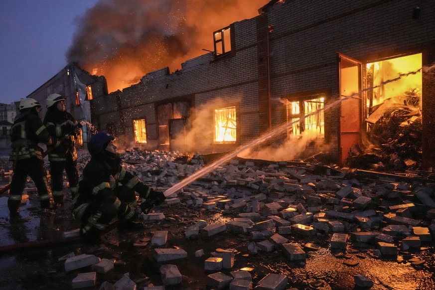 Ukrainian firefighters extinguish a blaze at a warehouse after a bombing in Kyiv, Ukraine, Thursday, March 17, 2022. Russian forces destroyed a theater in Mariupol where hundreds of people were shelte ...