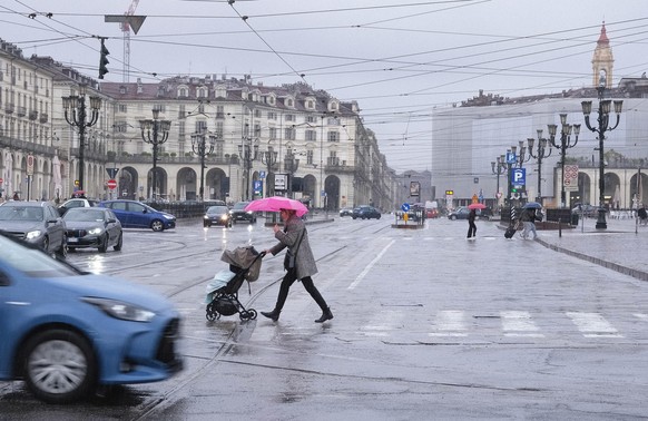 epa12035293 Pedestrian walk in heavy rain in Turin, Italy, 16 April 2025. The bad weather will intensify and bring very heavy rainfall to the mountainous and piedmont areas of northern and western Pie ...