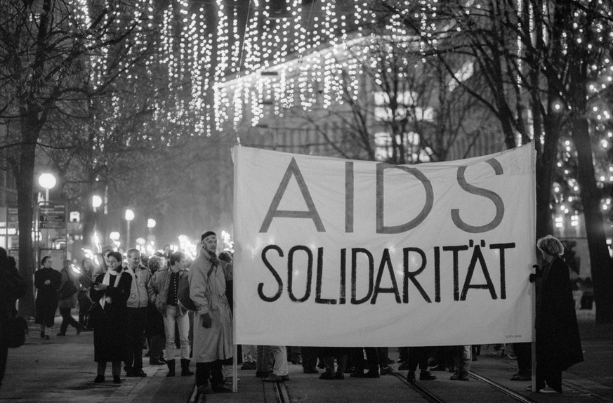 In Zuerich findet am 1. Dezember1990, aus Anlass des Welt-Aids-Tages der traditionelle Fackelumzug statt. Der Zug, der sich vor dem Grossmuenster besammelt und dann durch die Innenstadt zieht, wird vo ...