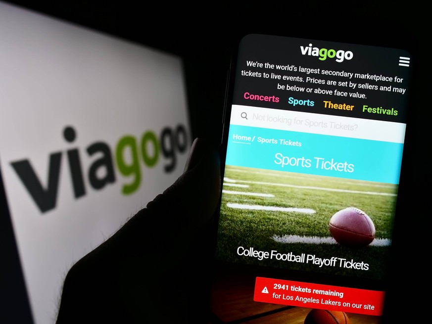 Person holding cellphone with webpage of US ticket exchange platform company Viagogo on screen. Stuttgart, Germany - 01-14-2023: Person holding cellphone with webpage of US ticket exchange platform co ...