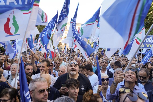 People wave flags as Right-wing party Brothers of Italy&#039;s leader Giorgia Meloni addresses a rally to starts her political campaign ahead of Sept. 25 general elections, in Ancona, Italy, Tuesday,  ...