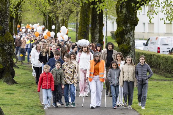 Des personnes prennent part a une marche blanche en hommage a la victime apres le feminicide d&#039;Epagny ce vendredi, 18 avril 2025 a Bulle. (KEYSTONE/Cyril Zingaro)