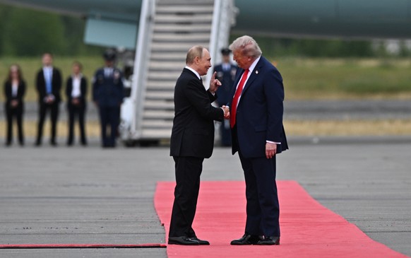 epaselect epa12303523 US President Donald Trump (R) welcomes Russian President Vladimir Putin during their meet to negotiate at Joint Base Elmendorf-Richardson in Anchorage, Alaska, USA, 15 August 202 ...