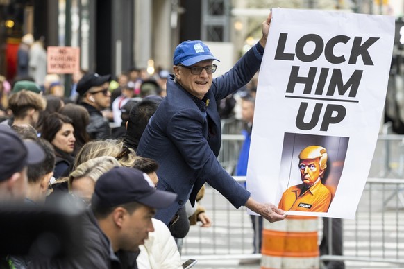 Un manifestant tient une pancarte devant la Trump Tower à New York, le lundi 3 avril 2023.