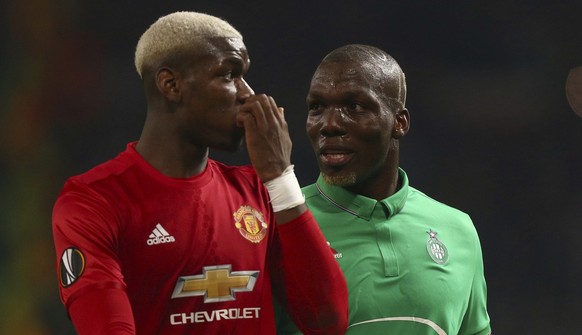 Manchester United&#039;s Paul Pogba, left, and St.-Etienne&#039;s Florentin Pogba during the Europa League round of 32 first leg soccer match between Manchester United and St.-Etienne at the Old Traff ...