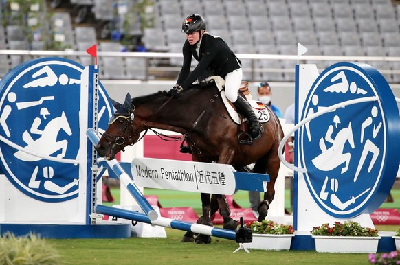epa09400046 Annika Schleu of Germany on Saint Boy hit an obstacle as they compete in the Show Jumping portion of the Modern Pentathlon event at the Tokyo 2020 Olympic Games at the Tokyo Stadium in Cho ...
