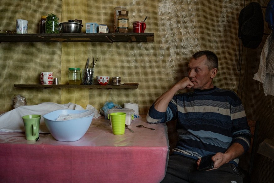 Igor Kniazev, assis dans la cuisine de sa maison construite à partir de caissons militaires russes dans le village de Dovhenke.