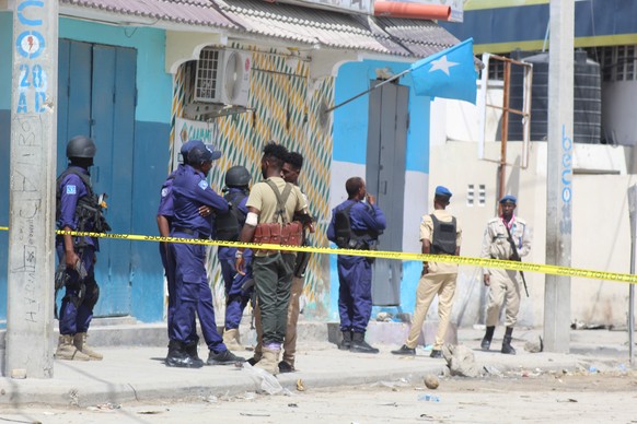 epa10130095 Somali security officials gather at the cordoned-off scene of an attack, outside the Hayat Hotel in Mogadishu, Somalia, 20 August 2022. According to Somalia