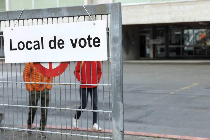 Des citoyens arrivent afin de voter dans le bureau de vote de Carouge, à Genève.
