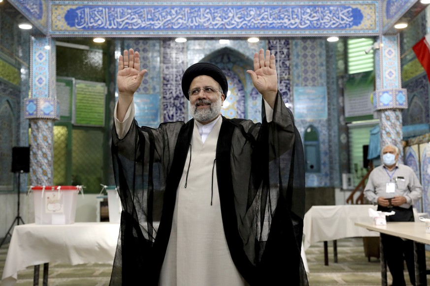 Ebrahim Raisi, a candidate in Iran's presidential elections waves to the media after casting his vote at a polling station in Tehran, Iran Friday, June 18, 2021. Iran began voting Friday in a pre ...