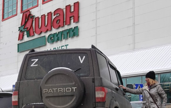 epaselect epa09853017 A car with the letters Z and V, which has been used by Russian forces as an identifying sign on their vehicles in Ukraine, parked in front of a French supermarket chain Auchan st ...