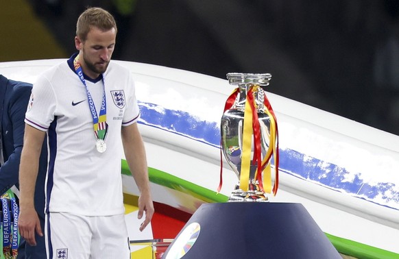 epa11479722 Harry Kane of England walks past the trophy after picking up his runner-up medal after the UEFA EURO 2024 final soccer match between Spain and England, in Berlin, Germany, 14 July 2024. Sp ...