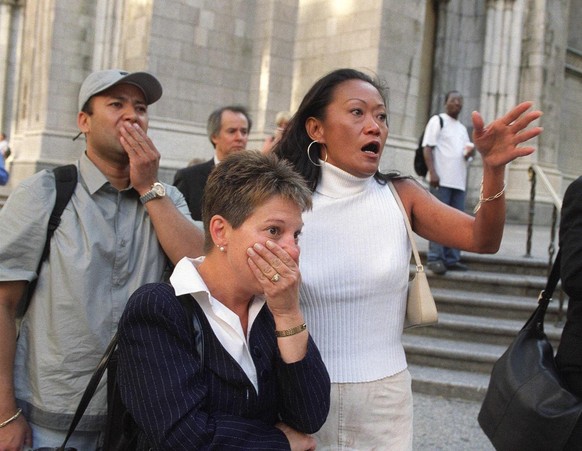 Les personnes qui se trouvent devant la cathédrale Saint-Patrick de New York réagissent avec horreur en regardant la Cinquième Avenue en direction des tours du World Trade Center, après que des avions ...