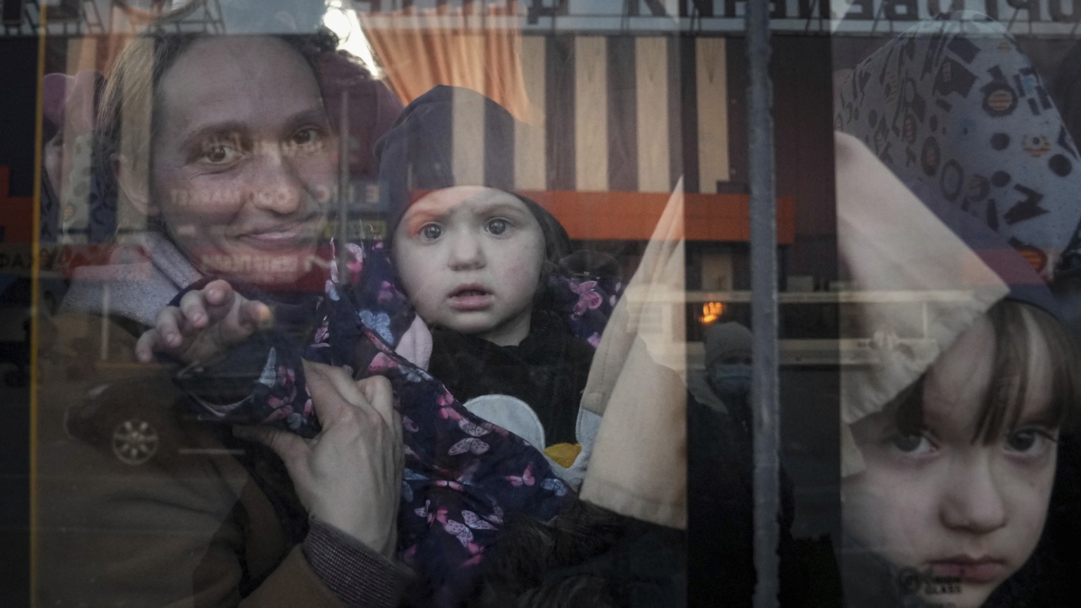 Internally displaced people look out from a bus at a refugee center in Zaporizhia, Ukraine, Friday, March 25, 2022. (AP Photo/Evgeniy Maloletka)