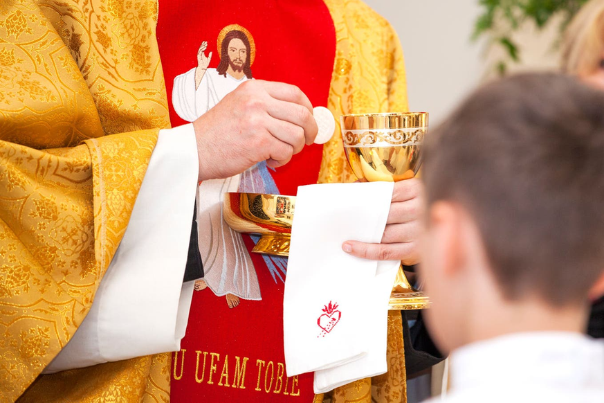 En réalité, le célibat est et était un mythe: un prêtre distribue la Sainte Communion.