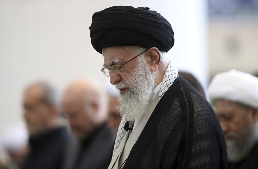 In this photo released by the official website of the office of the Iranian supreme leader, Supreme Leader Ayatollah Ali Khamenei leads Friday prayers at Imam Khomeini grand mosque, in Tehran, Iran, F ...