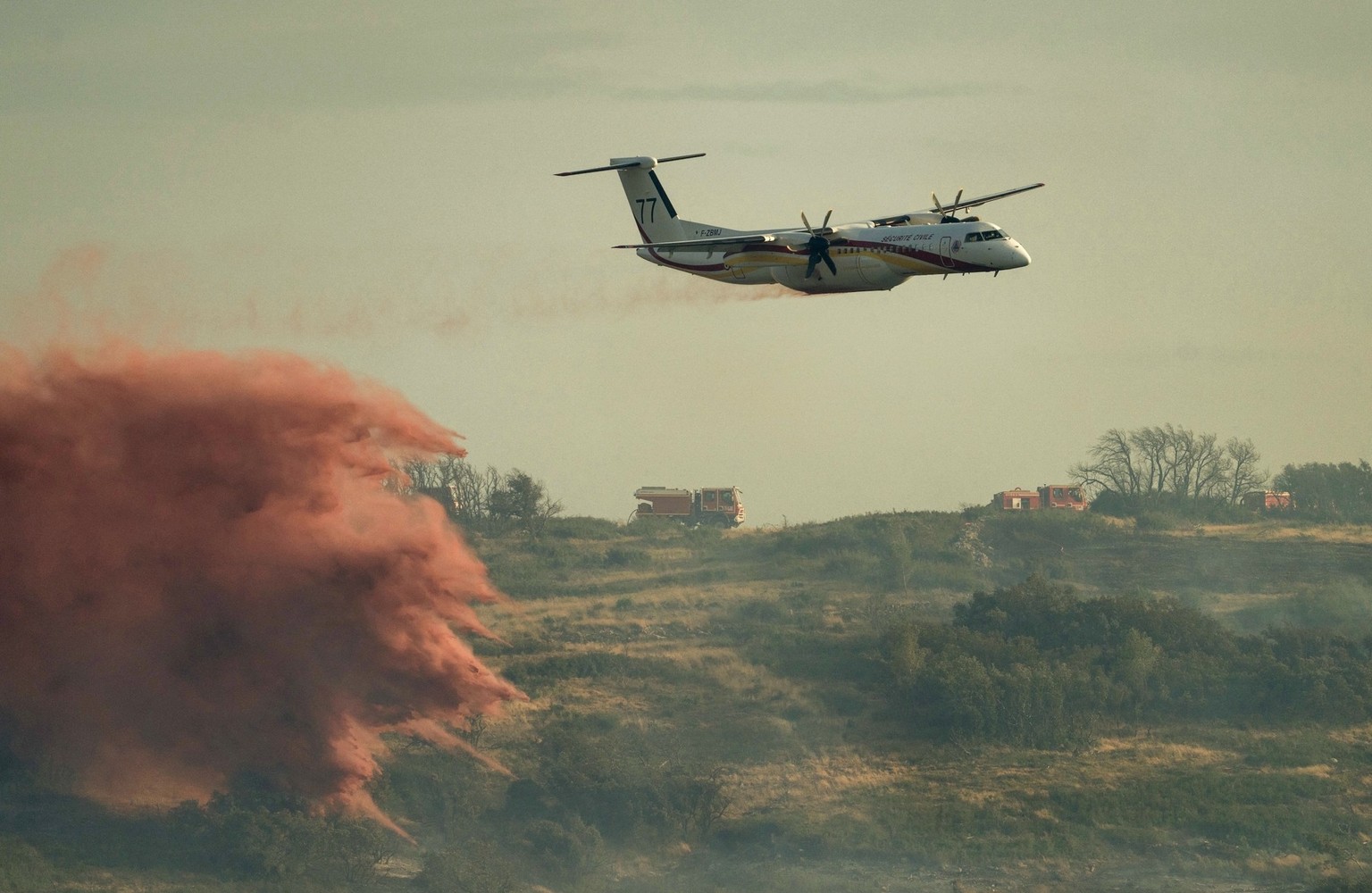 A DASH firefighting aircaft drops fire retardant during a wildfire near Fontcouverte, southwest France, on July 5, 2025. (Photo by IDRISS BIGOU-GILLES / AFP)