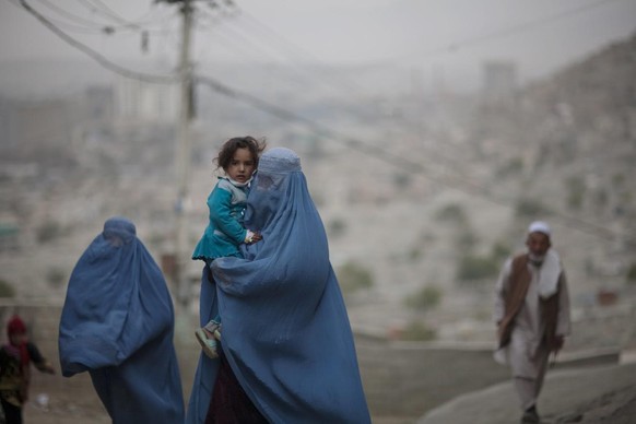 Une femme afghane vêtue d'une burqa porte une fillette à Kaboul, Afghanistan, jeudi 28 octobre 2010.