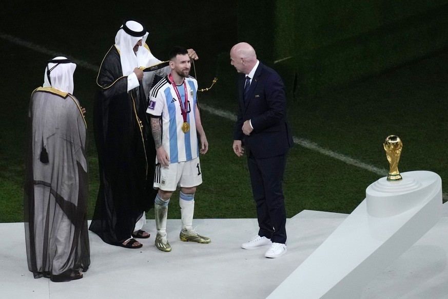 The Emir of Qatar Sheikh Tamim bin Hamad Al Thani puts a gown on to Argentina&#039;s Lionel Messi during the award ceremony of the World Cup at the Lusail Stadium in Lusail, Qatar, Sunday, Dec. 18, 20 ...