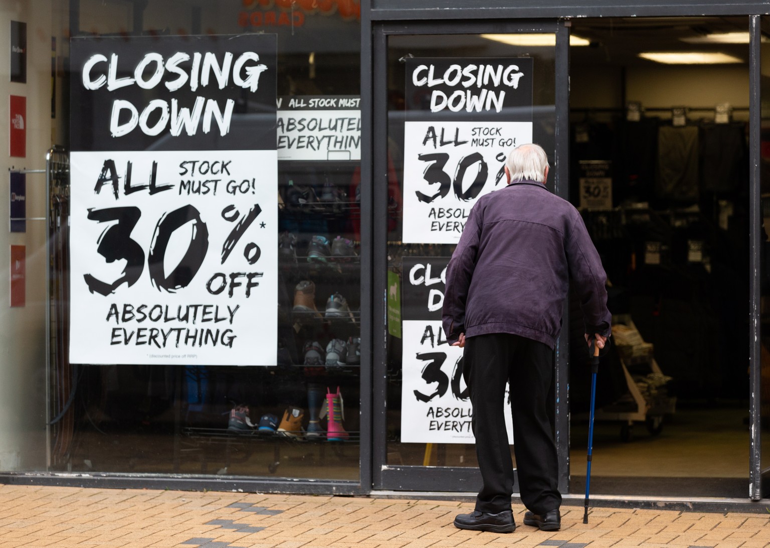 epa10431470 A person looks at closing down signs at a shop in Huddersfield, Britain, 26 January 2023. According to a study by think tank Institute for Public Policy Research (IPPR), the North of Engla ...