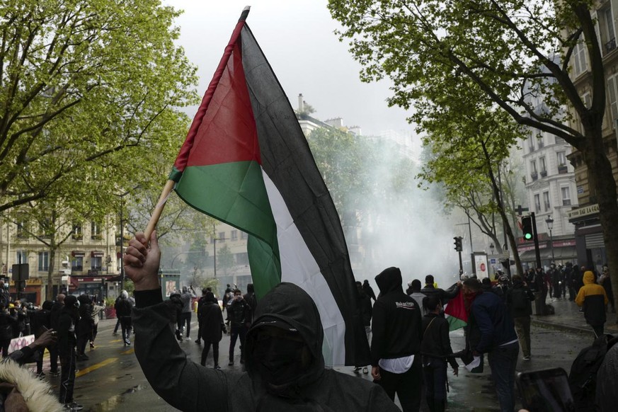 A demonstrator holds a Palestinian flag during a banned protest in support of Palestinians in the Gaza Strip, in Paris, Saturday, May, 15, 2021. Marches in support of Palestinians in the Gaza Strip we ...