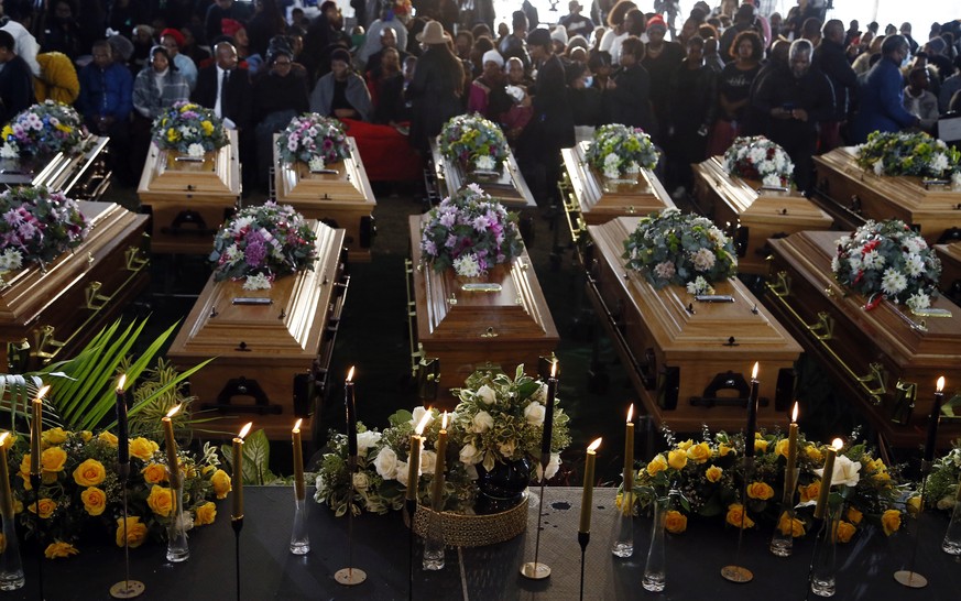 File - Coffins of 21 teenagers who died in a mysterious tragedy at a nightclub in the early hours of June 26, 2022 are lined up during their funeral held in Scenery Park, East London, South Africa, We ...