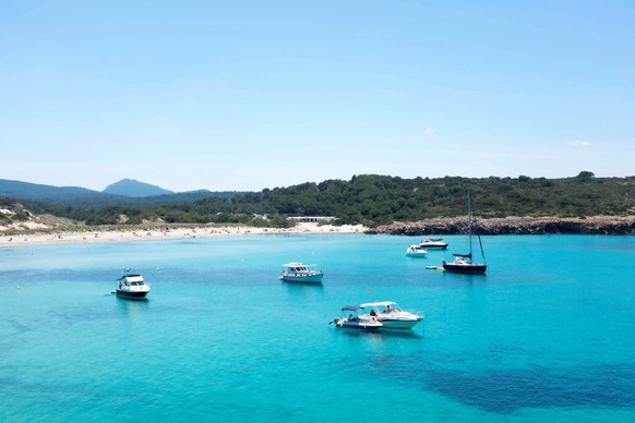 epa09268170 People enjoy a warm day at Son Parc beach in Menorca, Balearic Islands, Spain, 13 June 2021. EPA/David Arquimbau Sintes