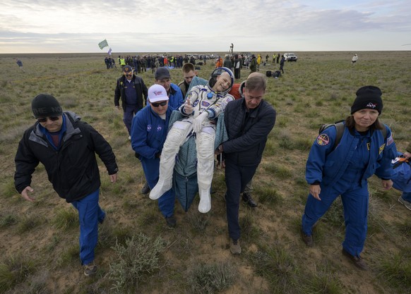 epa12042067 A handout photo made available by NASA shows NASA astronaut Don Pettit is carried to a medical tent shortly after he, and Roscosmos cosmonauts Alexey Ovchinin and Ivan Vagner landed in the ...