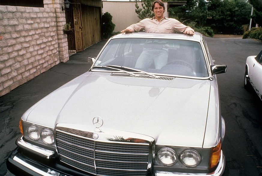 LOS ANGELES - CIRCA 1977: Austrian Bodybuilder Arnold Schwarzenegger poses for a photo standing in his Mercedes circa 1977 in Los Angeles, California. (Photo by Michael Ochs Archives/Getty Images)