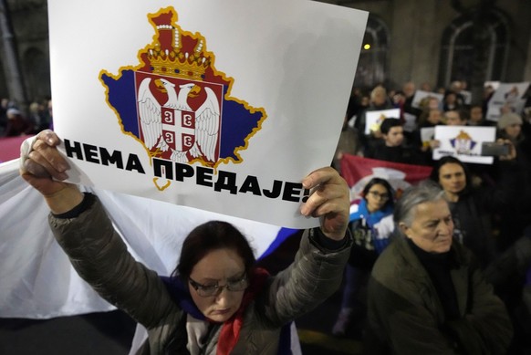 A man holds a banner showing a map of Kosovo and a Serbian coat of arms reading: &#039;&#039;No surrender!&#039;&#039; during a protest in support of Kosovo Serbs in Belgrade, Serbia, Friday, Dec. 16, ...