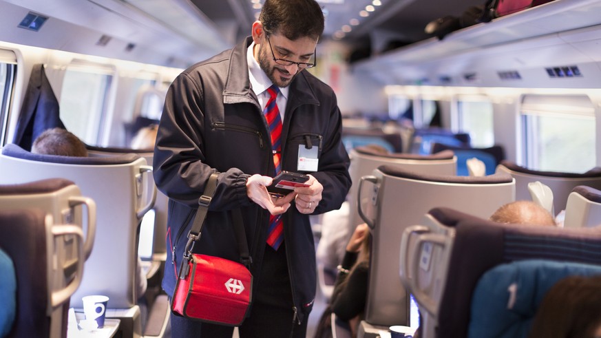 ZUR EINFUEHRUNG DES SWISSPASSES VOR DREI MONATEN STELLEN WIR IHNEN HEUTE, MITTWOCH, 4. NOVEMBER 2015, FOLGENDES NEUES BILDMATERIAL ZUR VERFUEGUNG --- Conductor Salvatore Grade verifies a train passeng ...