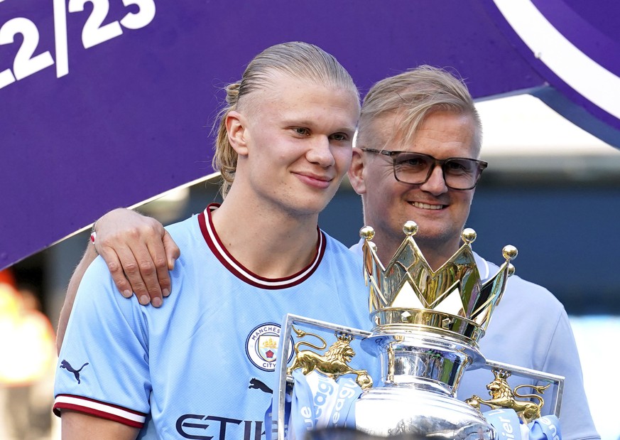 Manchester City&#039;s Erling Haaland and his father Alf-Inge Haaland pose for a photo with the Premier League trophy after their English Premier League title win at the end of the English Premier Lea ...