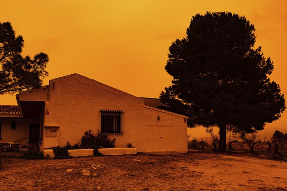 An orange sky is seen over a building in Navares, south eastern Spain, Monday March 14, 2022. Spain issued extremely poor air quality ratings for a large swathe of Spain Tuesday after a mass of hot ai ...