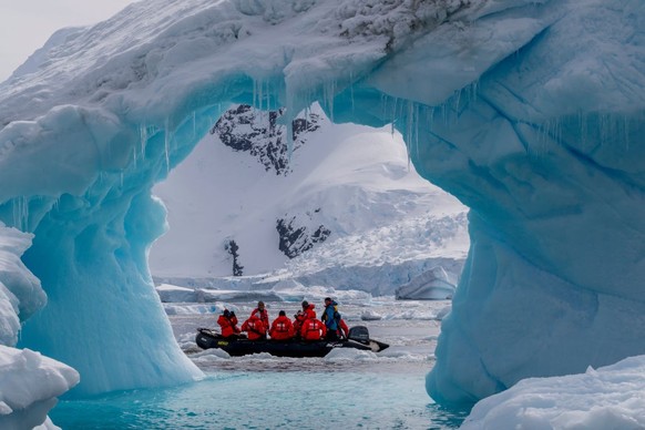 ANTARCTICA - 2022/11/27: Tourists in a zodiac exploring an iceberg arch in Cierva Cove, a cove along the west coast of Graham Land, Antarctic Peninsula, Antarctica. (Photo by Wolfgang Kaehler/LightRoc ...