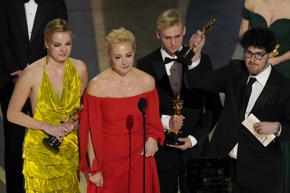 Family members of Alexei Navalny including daughter Dasha Navalnaya, from left, wife Yulia Navalnaya and son Zakhar Navalny, along with director Daniel Roher, accept the award for best documentary fea ...