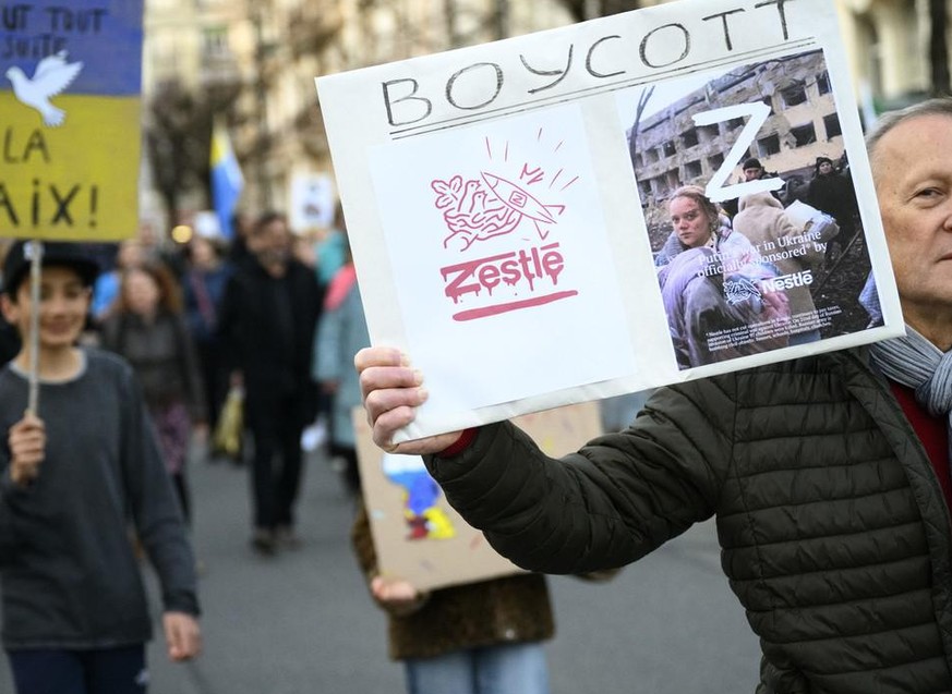 Protestors carry placards with &quot;Boycott Nestle&quot; as they take part in a demonstration against the Russian invasion of Ukraine on the sideline of the Financial Times Commodities Global Summit, ...