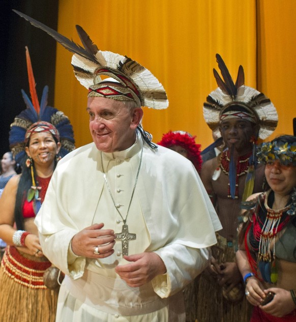 In this photo provided by the Vatican newspaper L&#039;Osservatore Romano, Pope Francis wears an indigenous headdress given to him by Ubirai Matos from the Pataxo tribe, not seen, after the pontiff sp ...