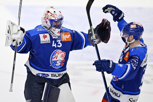 Der Zuercher Torhueter Jakub Kovar, links, und Maxim Noreau, rechts, jubeln nach dem Sieg im siebten Eishockey Playoff-Viertelfinalspiel der National League zwischen den ZSC Lions und dem EHC Biel-Bie ...