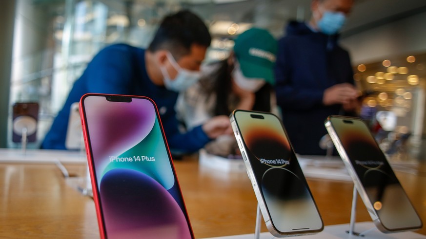 epa10283017 People look at i-Phone 14 models at an Apple store at a mall in Beijing, China, 03 November 2022. Around 600,000 people have been put in lockdown by Chinese authorities near the world&#039 ...