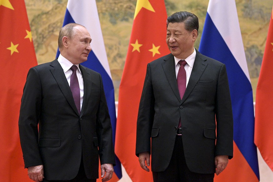 FILE - Chinese President Xi Jinping, right, and Russian President Vladimir Putin talk to each other during their meeting in Beijing, Friday, Feb. 4, 2022. Following this month