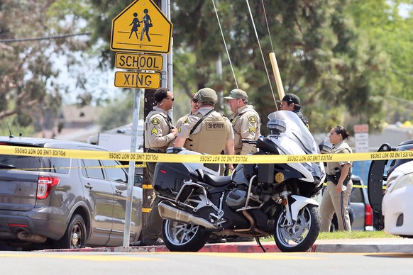 epa12972654 Law enforcement personnel gather on the scene to respond to an active shooting incident at the Islamic Center of San Diego, located in the Clairemont neighborhood in San Diego, California, ...