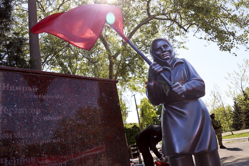 A sculpture of Ukrainian woman holding a Soviet-era red flag is seen during celebration of the 77th anniversary of the end of World War II in Mariupol, in territory under the government of the Donetsk ...