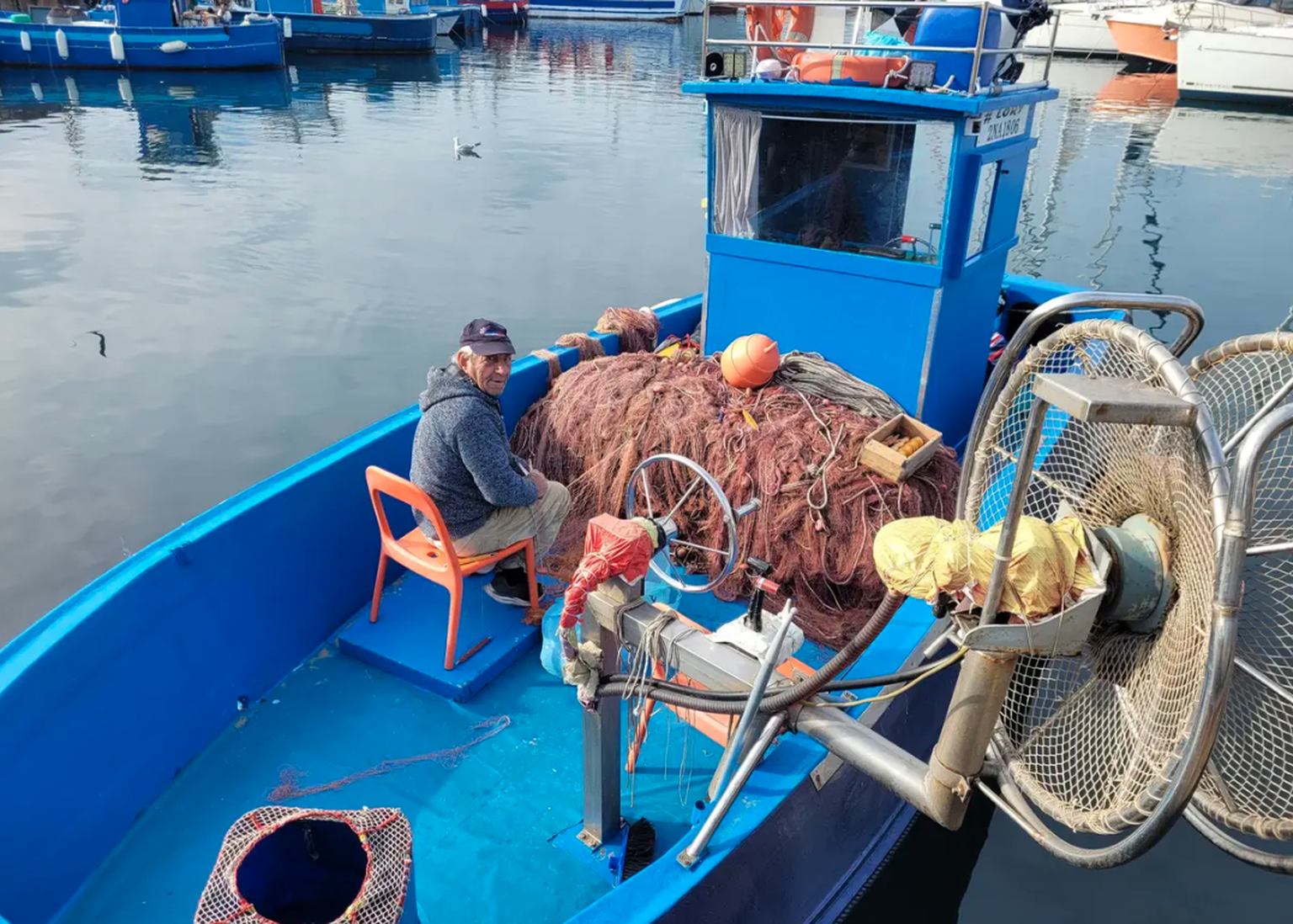 Pouzzoles: Le pêcheur Bruno répare ses filets - et se plaint du mur du port, qui dépasse désormais de trois mètres de l&#039;eau.