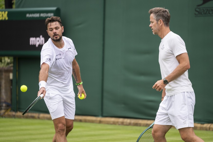 Stanislas Stan Wawrinka of Switzerland, left, with Coach Magnus Norman of Sweden, plays the ball during a practice session, ahead of the All England Lawn Tennis Championships in Wimbledon, London, Fri ...