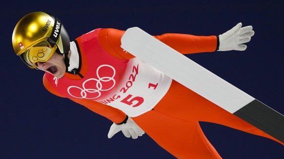 Dominik Peter, of Switzerland, soars through the air during a men&#039;s team ski jumping trial round for competition at the 2022 Winter Olympics, Monday, Feb. 14, 2022, in Zhangjiakou, China. (AP Pho ...
