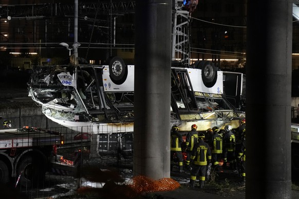 Italian firefighters work at the scene of a passenger bus accident in Mestre, near Venice, Italy, Wednesday, Oct. 4, 2023. According to local media, the bus fell a few meters from an elevated rod befo ...